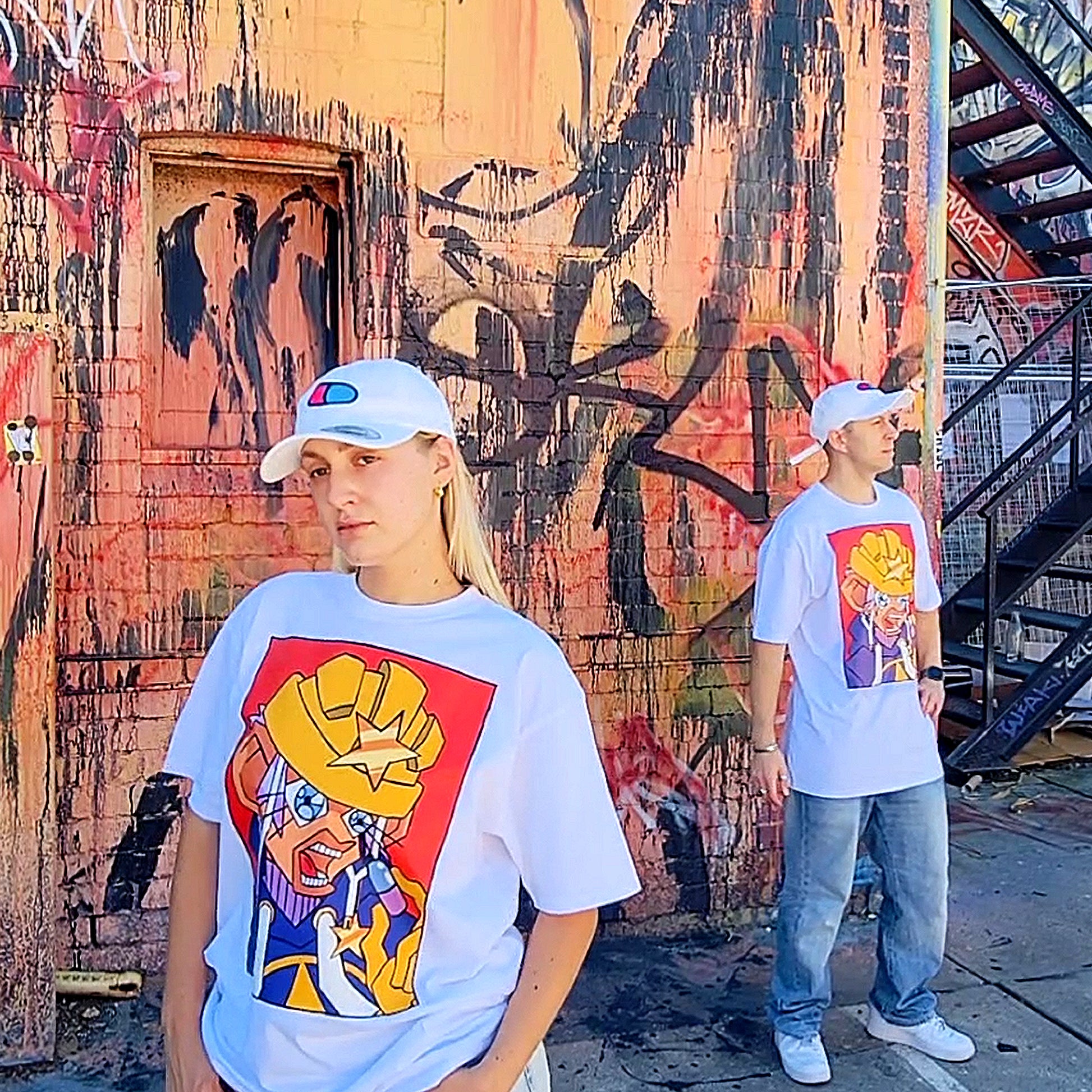Both Models Jordyn and Macie-J are standing with a graffiti wall in the background, posing and wearing (anime inspired graphic t) Mahou Shounen Star B-Side Kick T Shirt 
