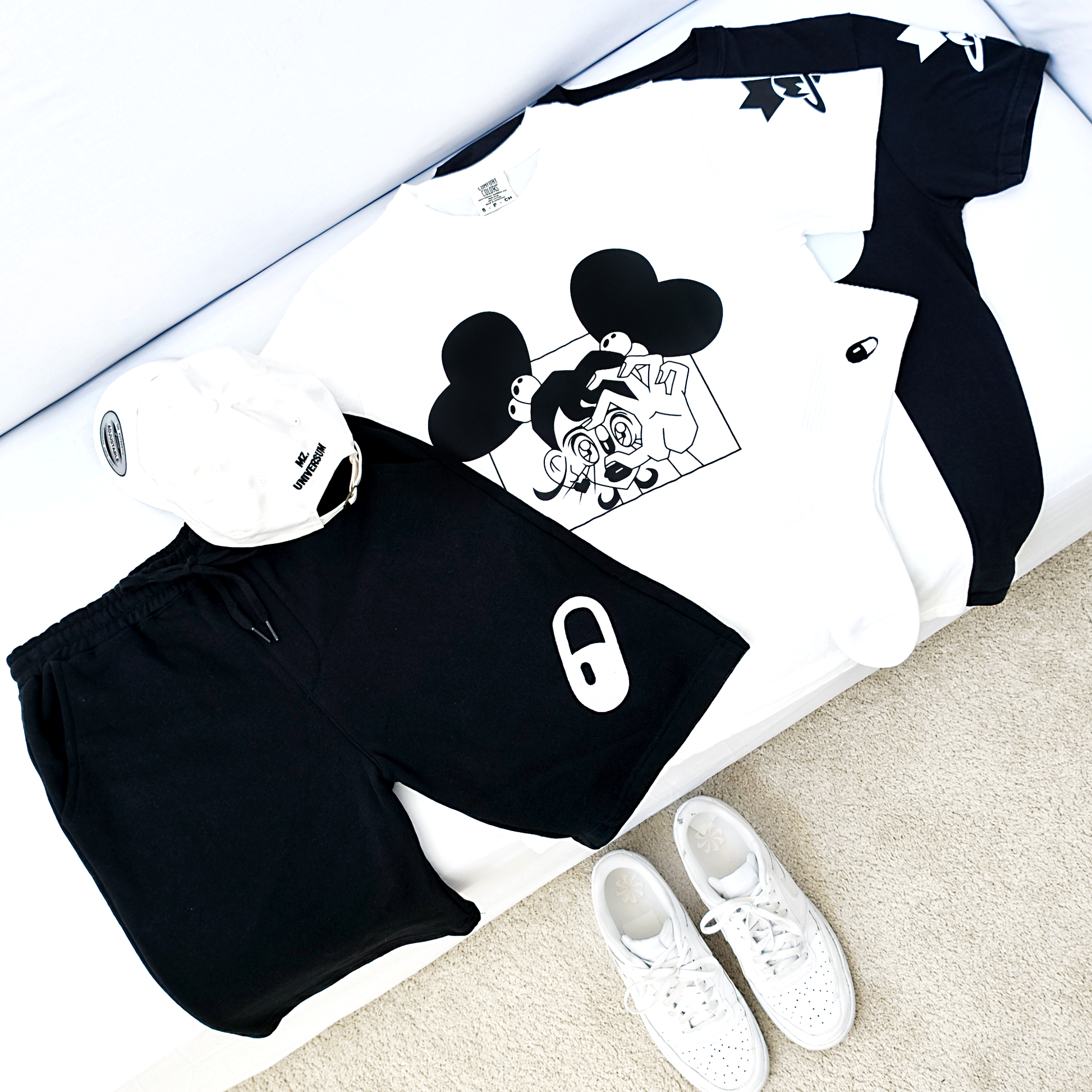 Collection 2 The Pill Flatley of black and white outfit with shorts, t-shirt, and socks on a white surface.