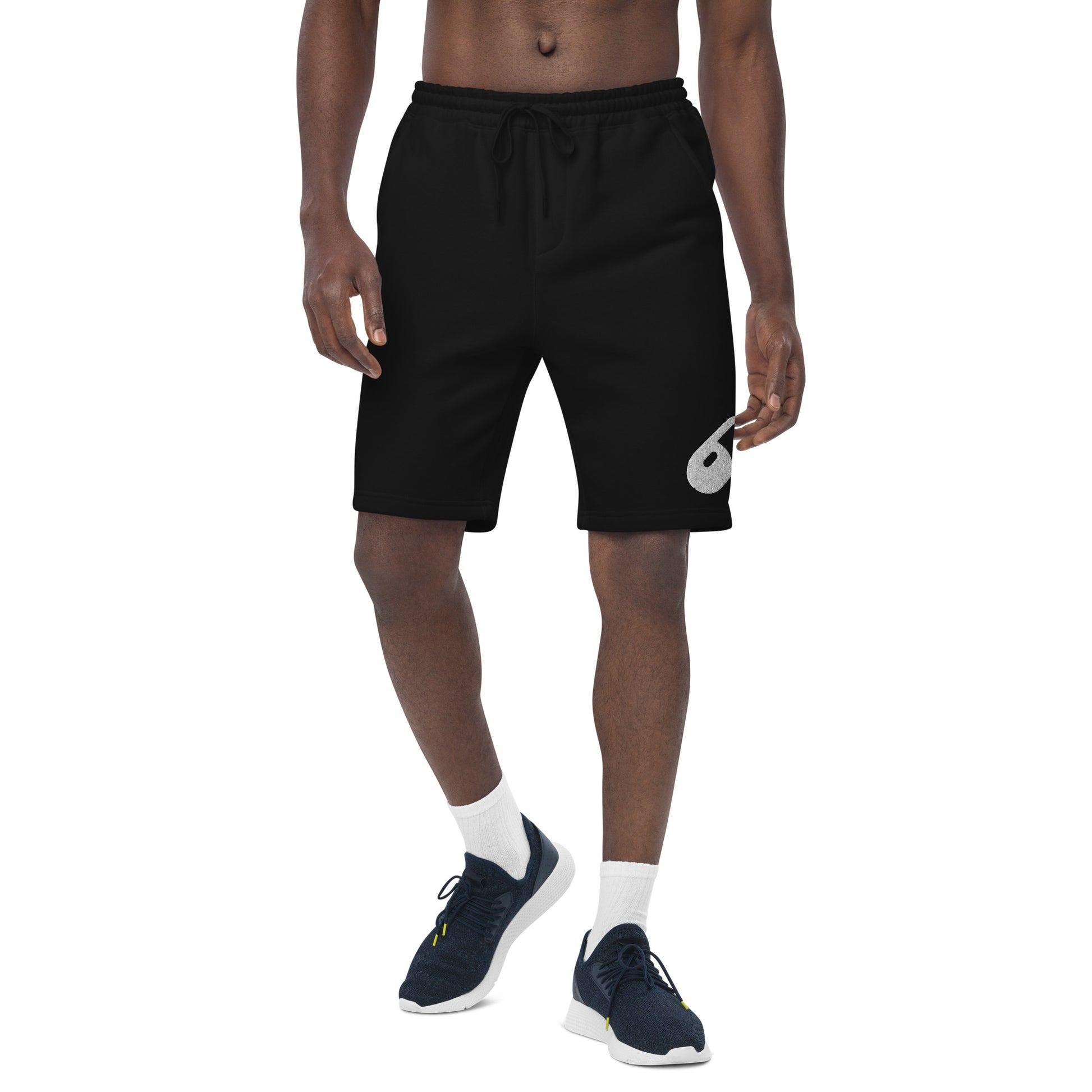 Model wearing the black fleece shorts from the front, showing the relaxed fit and tapered knee opening.